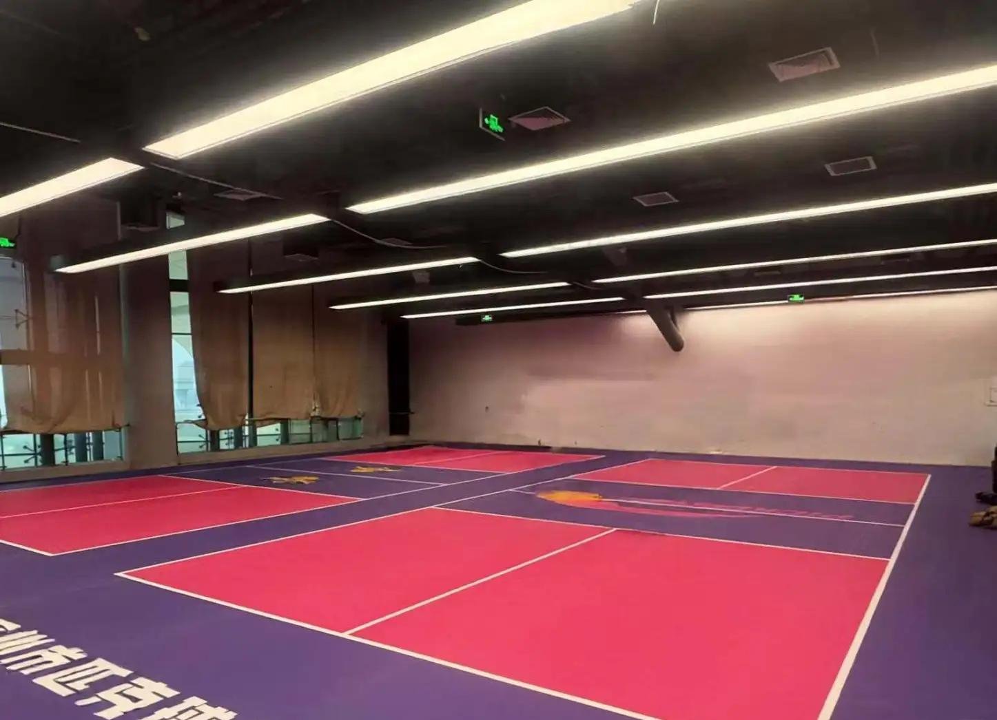 Technician inspecting PVC sports flooring seams before reinstallation